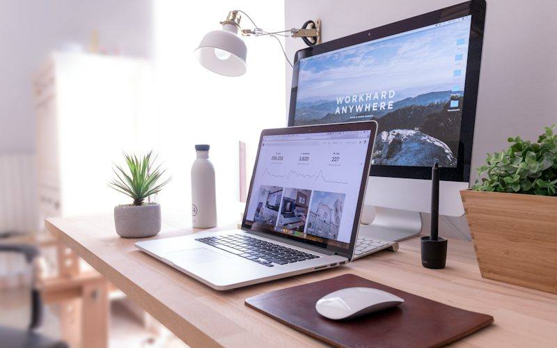 Laptop and desktop monitor showing a business website layout